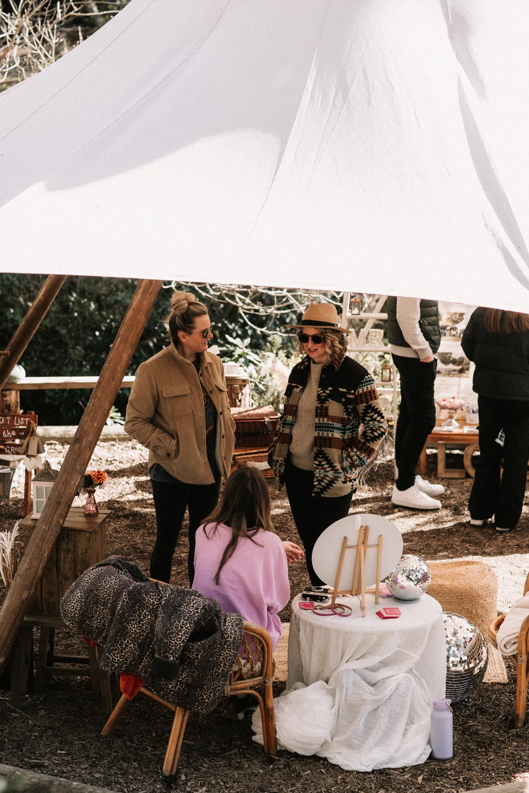 Guests talk at a table inside the white tipi.