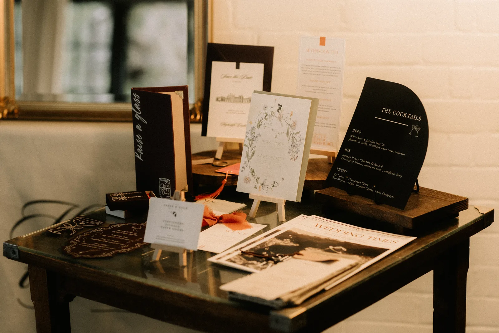Stationery samples propped on a dark wooden table.